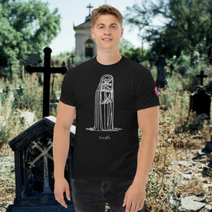 Man wearing a black Solitary Embrace t-shirt with white line art of a skeleton cloaked in darkness, arms wrapped around itself, standing in a graveyard.