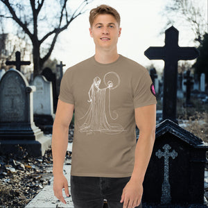 Man wearing a brown savana Eternal Vigil t-shirt with white line art of a robed figure holding a skull, standing in a cemetery surrounded by tombstones.