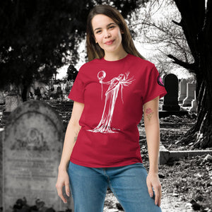 Woman wearing a cardinal red Phantom’s Waltz t-shirt with white line art of a ghostly figure holding a skull, standing in a graveyard with headstones behind her.