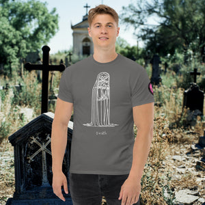 Man wearing a charcoal Solitary Embrace t-shirt with white line art of a skeleton cloaked in darkness, arms wrapped around itself, standing in a graveyard.