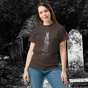 Woman wearing AETHEREUM CORPUS dark chocolate t-shirt with white line art corpse drawing, posed in a gothic graveyard.