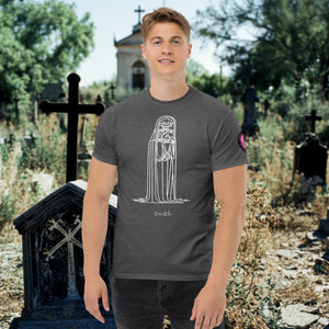 Man wearing a dark heather Solitary Embrace t-shirt with white line art of a skeleton cloaked in darkness, arms wrapped around itself, standing in a graveyard.