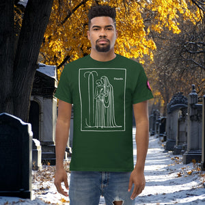 Man wearing a forest green Silent Vigil t-shirt with white line art of Death standing in a framed scene, graveyard path dusted with snow in the background.