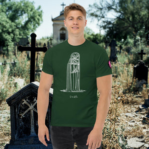 Man wearing a forest green Solitary Embrace t-shirt with white line art of a skeleton cloaked in darkness, arms wrapped around itself, standing in a graveyard.