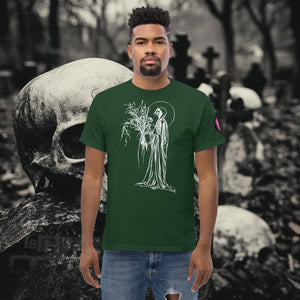 Man wearing a forest green Reaper’s Harvest t-shirt with white line art of a skeletal figure holding flowers, standing before a background of skulls and gravestones.