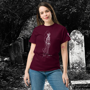 Woman wearing AETHEREUM CORPUS maroon t-shirt with white line art corpse drawing, posed in a gothic graveyard.