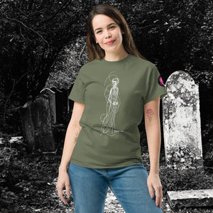 Woman wearing AETHEREUM CORPUS military green t-shirt with white line art corpse drawing, posed in a gothic graveyard.