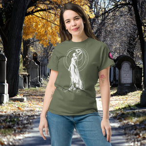 Woman wearing a military green Wraith’s Reverie t-shirt with white line art of the Grim Reaper in graceful pose, surrounded by autumn trees and gravestones.