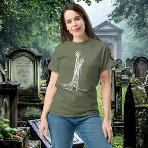 Man wearing a military green Skeletal Serenity Classic Tee with white line art of Death holding flowers, standing in a gothic graveyard.