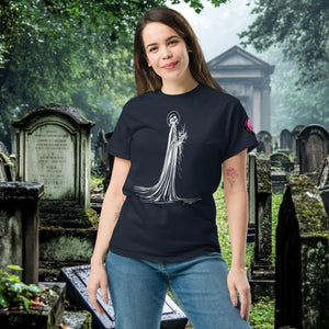 Man wearing a navy Skeletal Serenity Classic Tee with white line art of Death holding flowers, standing in a gothic graveyard.