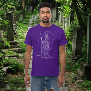 Man wearing a purple Grim Sentinel t-shirt with white line art of a cloaked reaper holding a scythe and skull, standing on a mossy cemetery path.