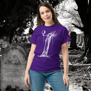 Woman wearing a purple Phantom’s Waltz t-shirt with white line art of a ghostly figure holding a skull, standing in a graveyard with headstones behind her.