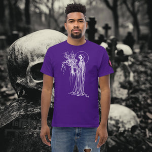 Man wearing a purple Reaper’s Harvest t-shirt with white line art of a skeletal figure holding flowers, standing before a background of skulls and gravestones.