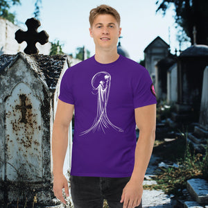 Man wearing a purple Veil of Solitude t-shirt with white line art of the Grim Reaper lifting a skull, standing among sunlit mausoleums in a cemetery.