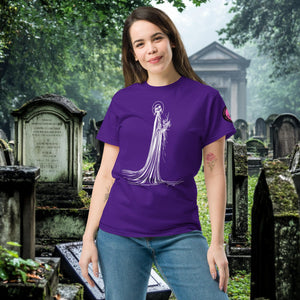 Man wearing a purple Skeletal Serenity Classic Tee with white line art of Death holding flowers, standing in a gothic graveyard.