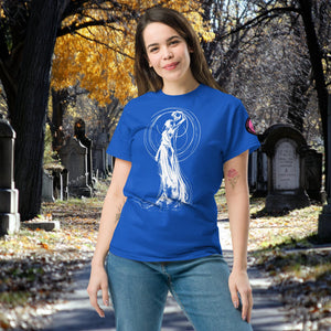 Woman wearing a royal blue Wraith’s Reverie t-shirt with white line art of the Grim Reaper in graceful pose, surrounded by autumn trees and gravestones.
