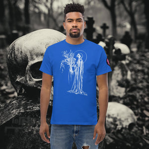 Man wearing a royal blue Reaper’s Harvest t-shirt with white line art of a skeletal figure holding flowers, standing before a background of skulls and gravestones.