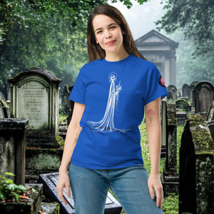 Man wearing a royal blue Skeletal Serenity Classic Tee with white line art of Death holding flowers, standing in a gothic graveyard.