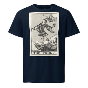 Mid-light organic cotton t-shirt featuring The Fool tarot card with cliff, dog, and sun in high-contrast woodcut rendering.