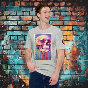 A man wearing an athletic heather Discordance Core Tee with vibrant skull dripping in color, standing before a blue and orange graffiti wall.
