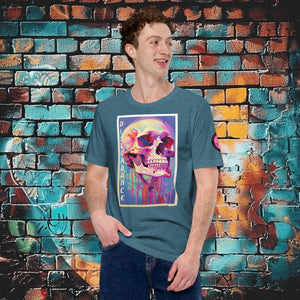 A man wearing a heather deep teal Discordance Core Tee with vibrant skull dripping in color, standing before a blue and orange graffiti wall.