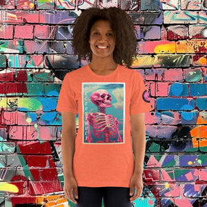 Woman wearing a heather orange Deconstruct Core Tee with colorful skeletal design gazing upward, standing before a vibrant graffiti wall.