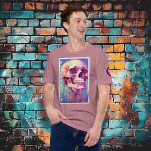A man wearing a heather orchid Discordance Core Tee with vibrant skull dripping in color, standing before a blue and orange graffiti wall.