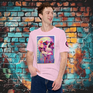 A man wearing a heather prism lilac Discordance Core Tee with vibrant skull dripping in color, standing before a blue and orange graffiti wall.