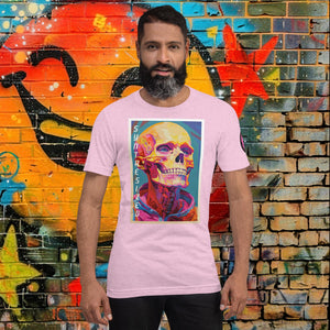 Man wearing a heather prism lilac Synthesized Futility Core Tee with bright multicolor skull artwork and “SYNTHESIZED” text, standing before graffiti mural.