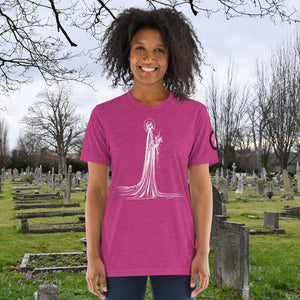 A woman wearing a berry tri-blend Skeletal Serenity Premium Tee with elegant line art of Death holding flowers, sunset cemetery backdrop.