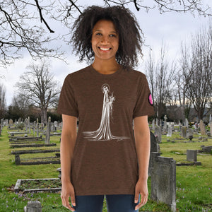 A woman wearing a brown tri-blend Skeletal Serenity Premium Tee with elegant line art of Death holding flowers, sunset cemetery backdrop.