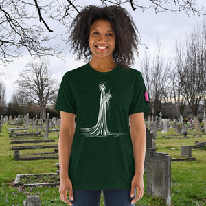 A woman wearing an emerald tri-blend Skeletal Serenity Premium Tee with elegant line art of Death holding flowers, sunset cemetery backdrop.