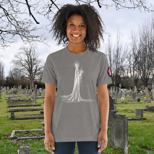 A woman wearing a grey tri-blend Skeletal Serenity Premium Tee with elegant line art of Death holding flowers, sunset cemetery backdrop.