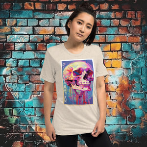 Woman wearing an oatmeal triblend Discordance Premium Tee with surreal neon skull artwork against a colorful graffiti backdrop.