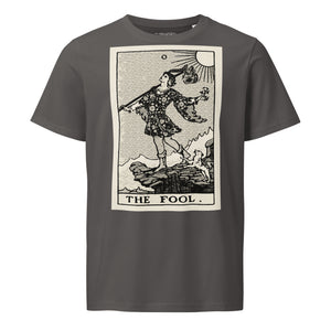 Mid-light organic cotton t-shirt featuring The Fool tarot card with cliff, dog, and sun in high-contrast woodcut rendering.