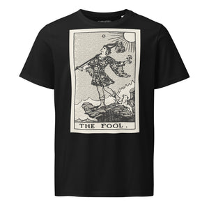 Mid-light organic cotton t-shirt featuring The Fool tarot card with cliff, dog, and sun in high-contrast woodcut rendering.