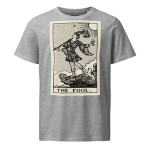 Mid-light organic cotton t-shirt featuring The Fool tarot card with cliff, dog, and sun in high-contrast woodcut rendering.