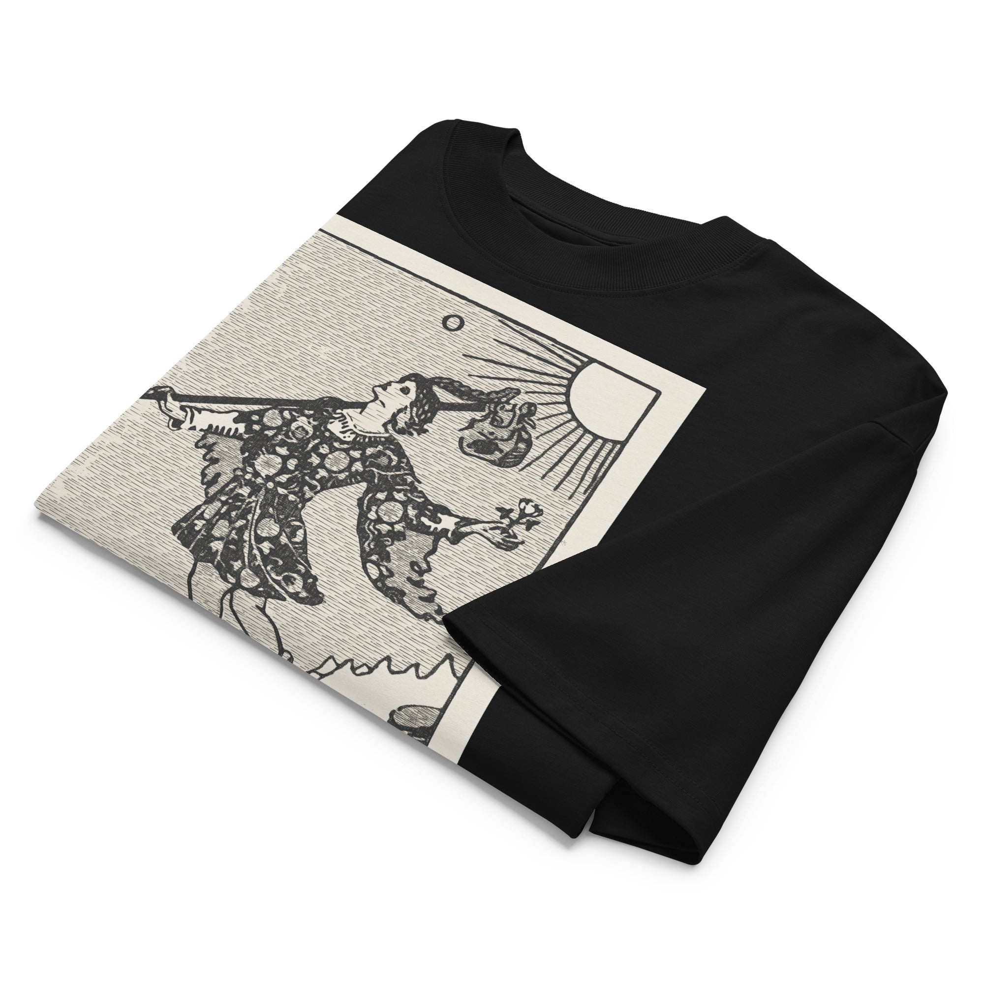 Oversized organic cotton t-shirt displaying The Fool tarot card with cliff, dog, and rising sun in modern woodcut style.