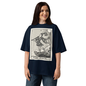 Oversized organic cotton t-shirt displaying The Fool tarot card with cliff, dog, and rising sun in modern woodcut style.