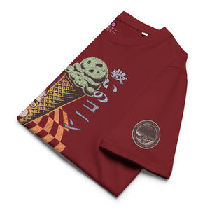 The lfolded view of a burgundy heavyweight tee featuring half of an ice cream cone and the Japanese kanji 救いのコーン (Sukui no kōn) — “Cone of Salvation." There is a circular badge of mothman over a bridge with the words "artificial perdition | myths & legends."