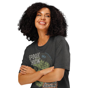A woman standing with arms crossed wearing a distressed Frankenstein head with “Spook Show” on a premium organic  heavyweight dark heather t-shirt.