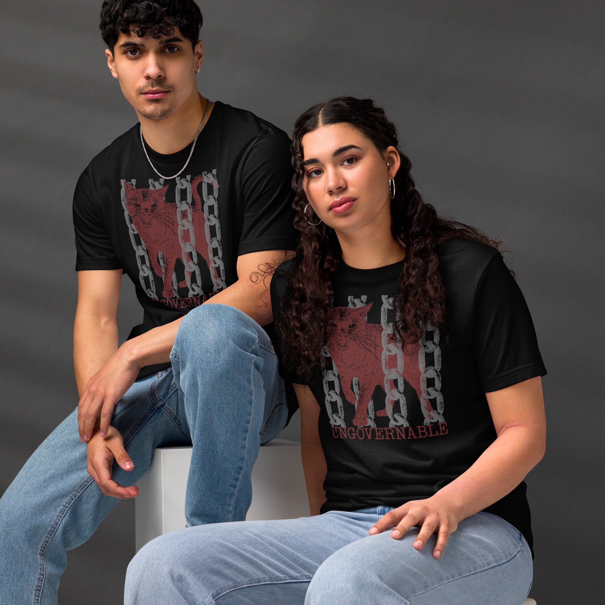 Snarling cat breaking through chains with UNGOVERNABLE text, dithered halftone red on cream, Artificial Perdition apparel
