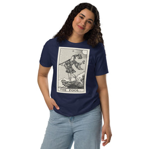 Recycled blend t-shirt featuring The Fool tarot card, showing a traveler at a cliff edge with a dog and rising sun in a modern woodcut style.