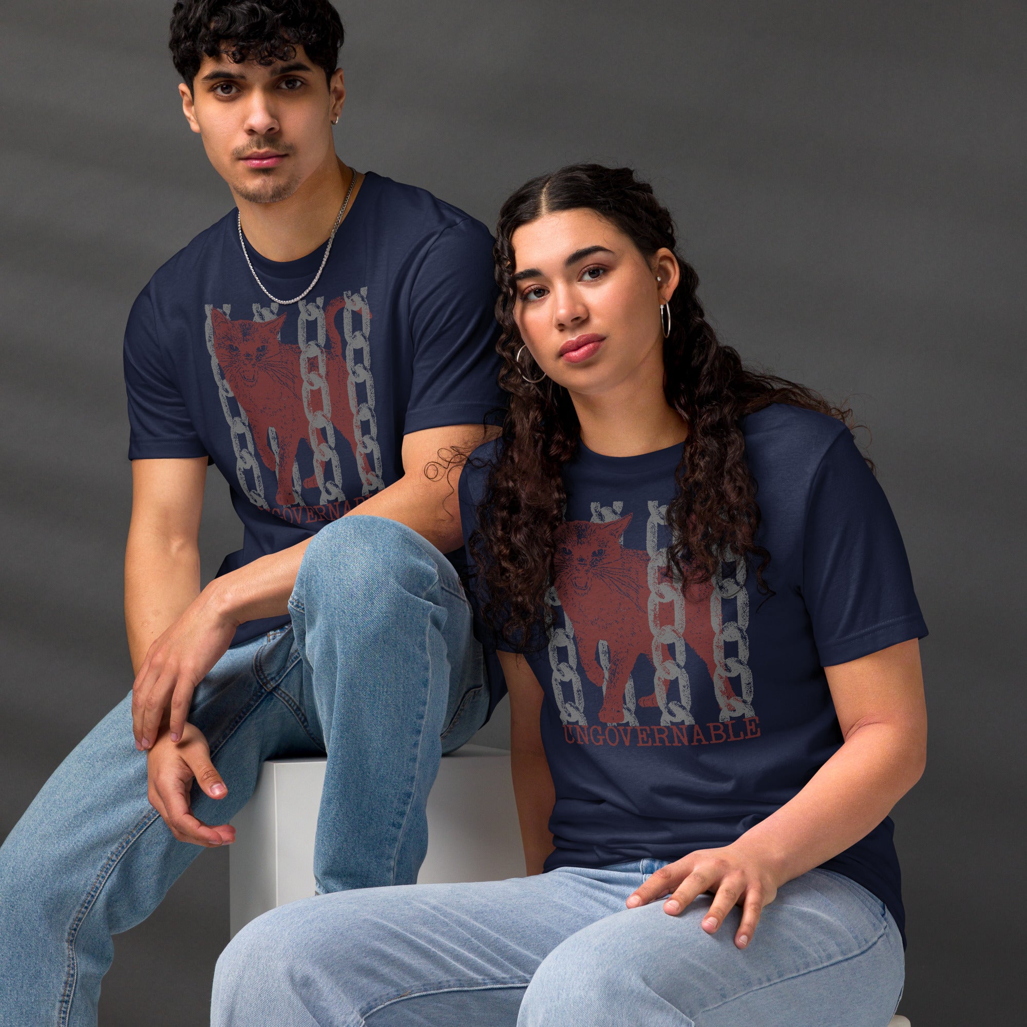 Snarling cat breaking through chains with UNGOVERNABLE text, dithered halftone red on cream, Artificial Perdition apparel