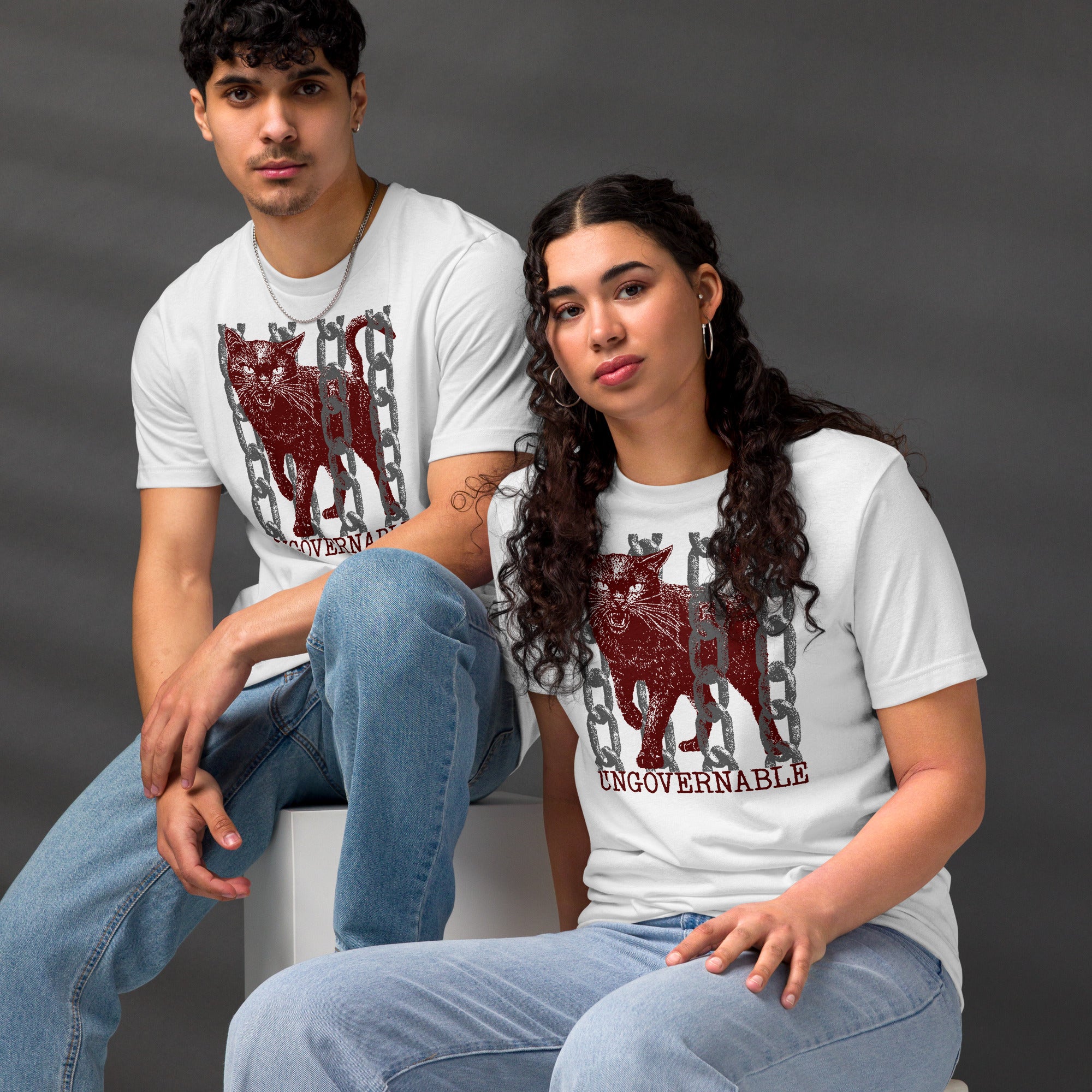 Snarling cat breaking through chains with UNGOVERNABLE text, dithered halftone red on cream, Artificial Perdition apparel