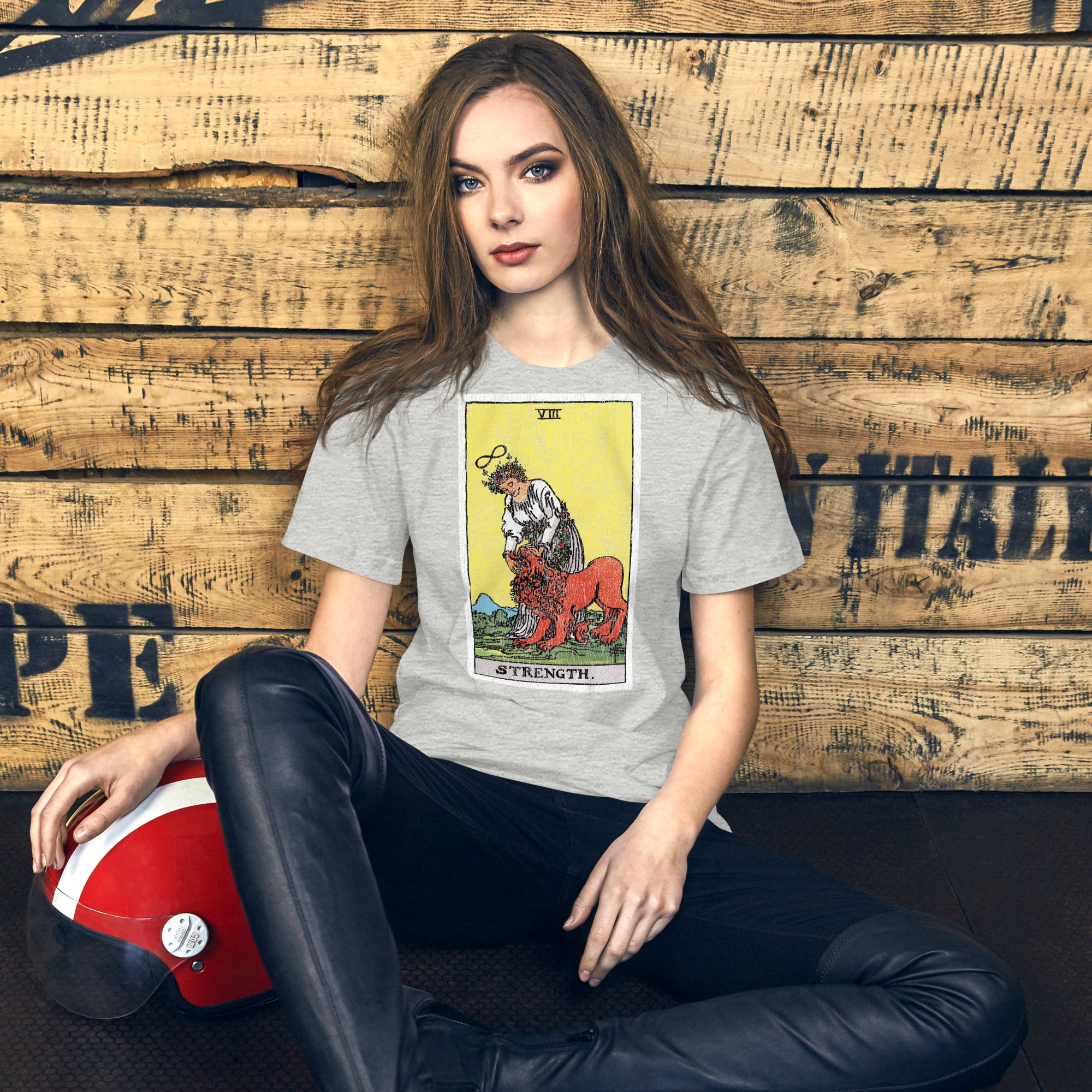 Card eight. The lion is already subdued, led by a chain of flowers. Strength is the quiet kind — fortitude, not force. Rider-Waite tarot apparel.