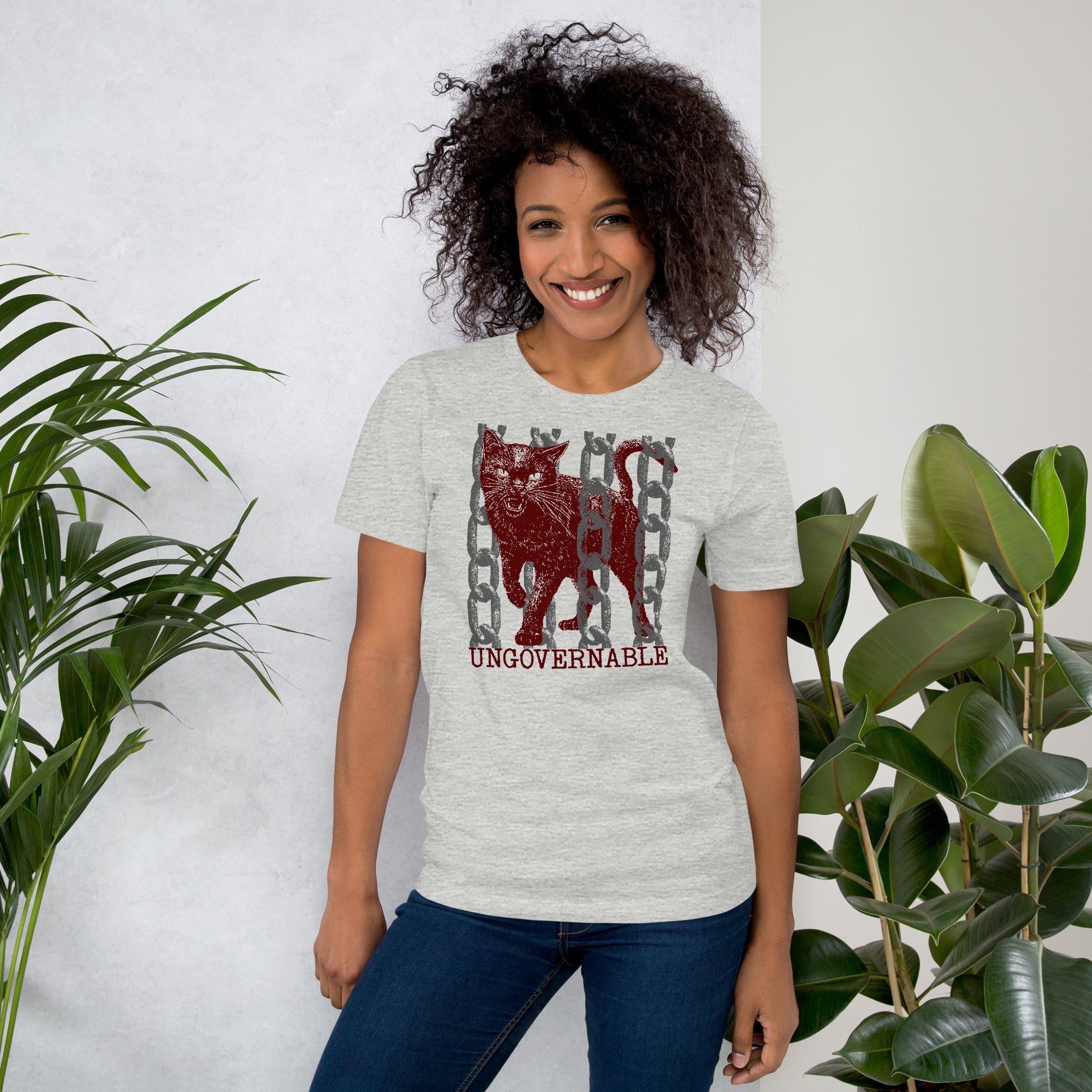 Product mockupSnarling cat breaking through chains with UNGOVERNABLE text, dithered halftone red on cream, Artificial Perdition apparel