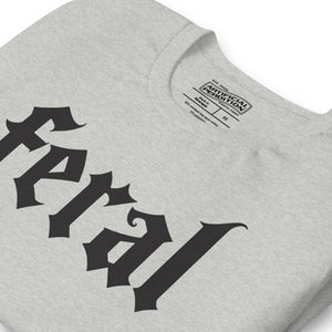 Feral in white blackletter font on dark heather grey t-shirt, bold single word graphic design, Artificial Perdition apparel