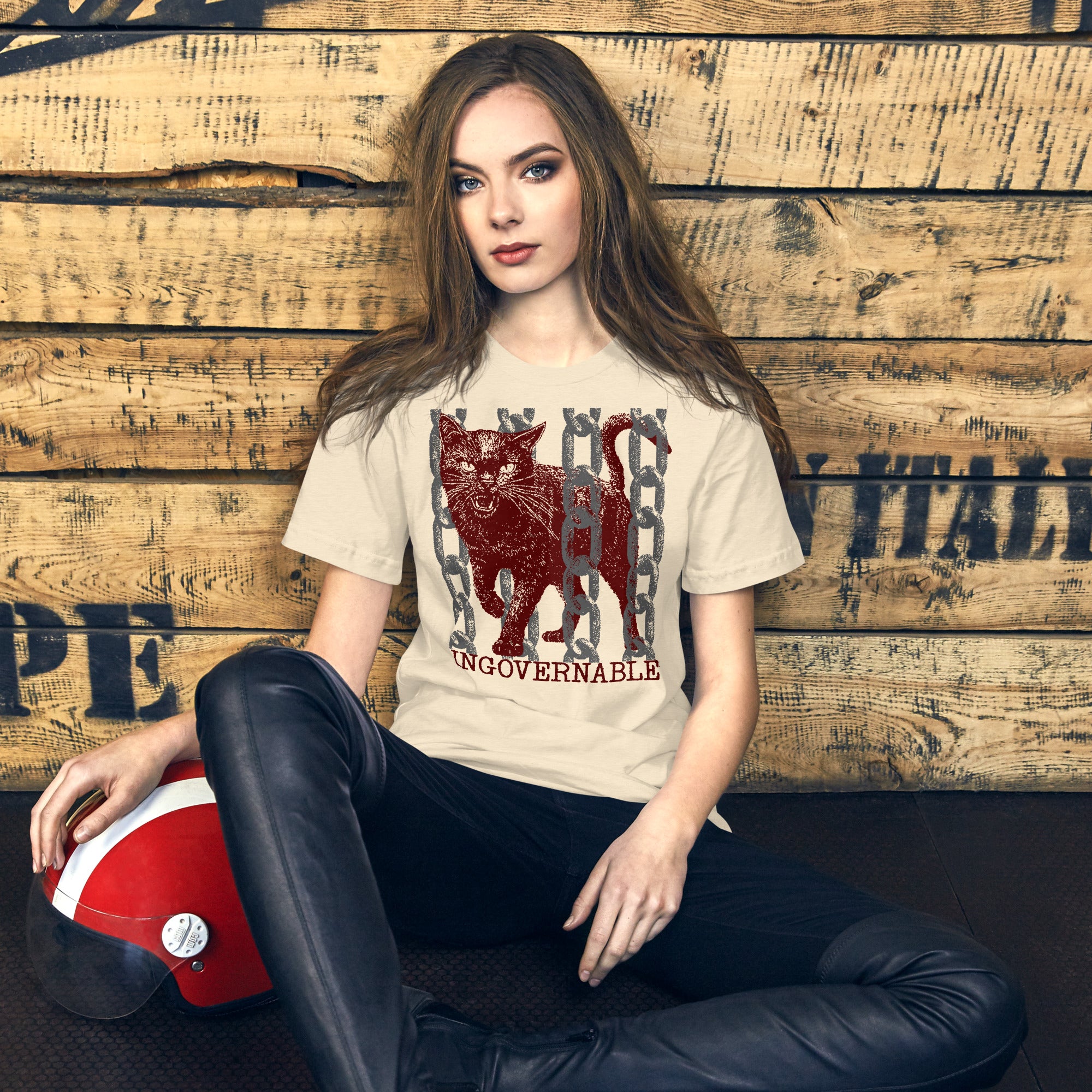 Snarling cat breaking through chains with UNGOVERNABLE text, dithered halftone red on cream, Artificial Perdition apparel