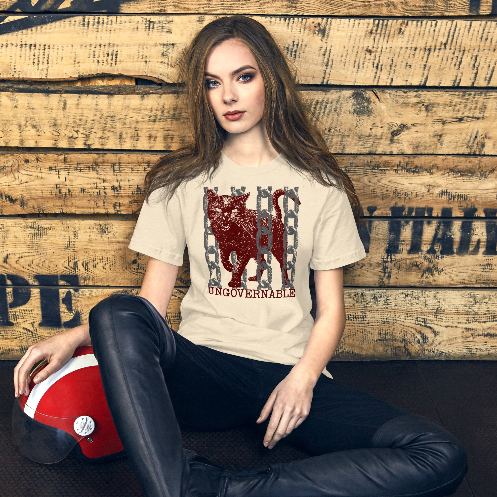 Product mockupSnarling cat breaking through chains with UNGOVERNABLE text, dithered halftone red on cream, Artificial Perdition apparel